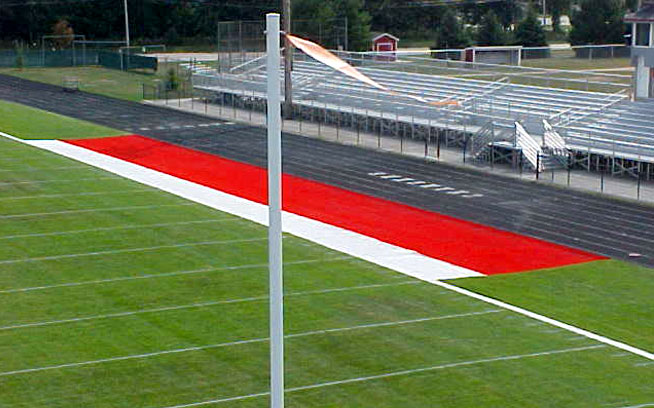 Artificial grass sideline with red end-zone accent beside a football field