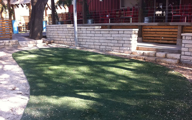 Shaded restaurant play area surfaced with artificial grass