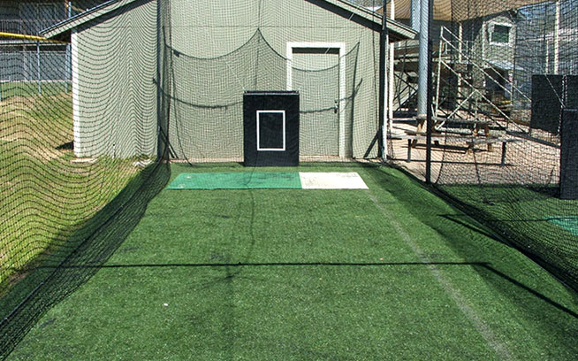 Artificial grass lining the floor of an outdoor batting cage