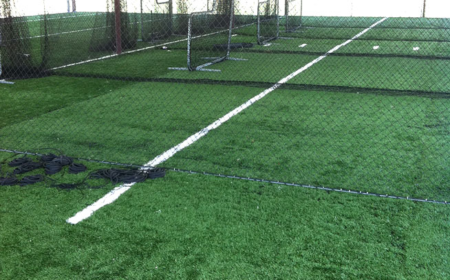 Wide view of an artificial grass hitting area with white lines